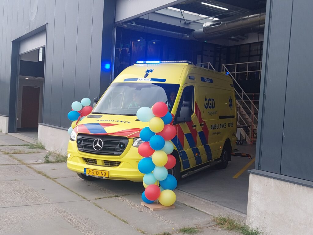 ambulance rijdt door rood lint